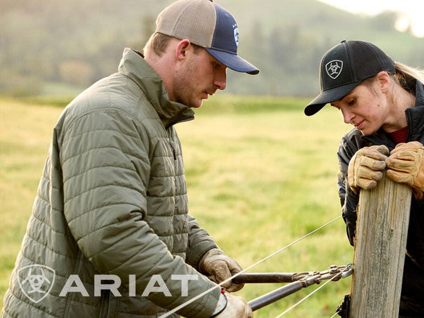 Man working in the outdoors wearing Ariat work gear - cap, jacket, 