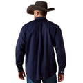 Man wearing a navy blue shirt and brown cowboy hat on a beige background