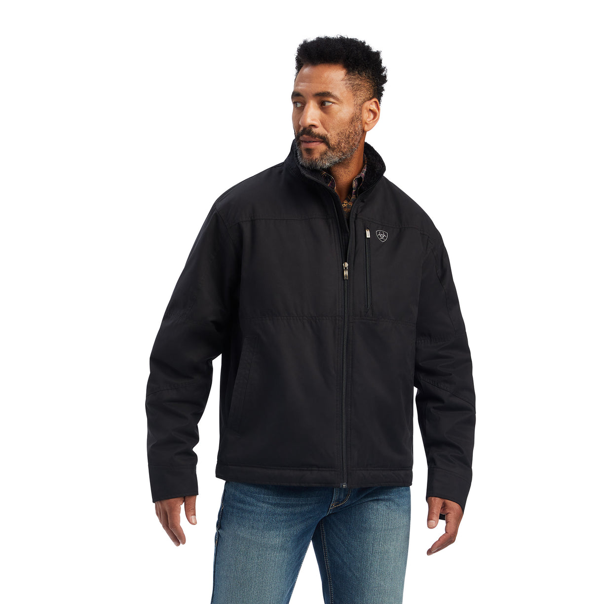 A man wearing a black Grizzly canvas jacket with a sherpa lined collar, multiple zippered pockets, and standing collar.