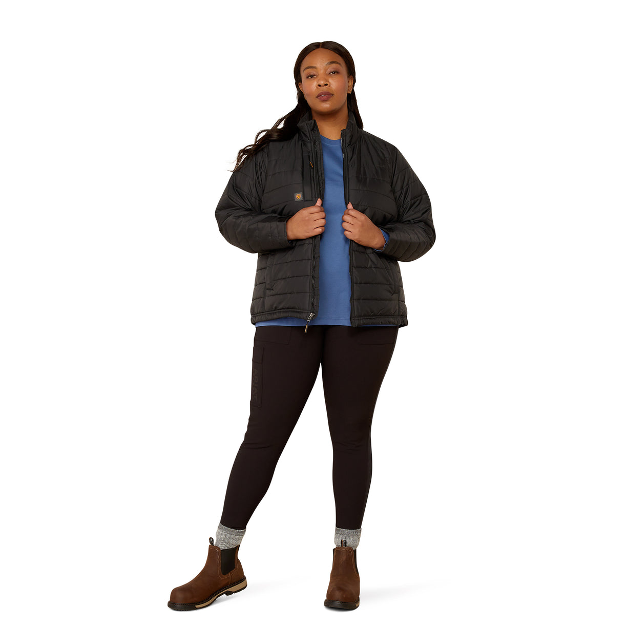 Person wearing a black puffer jacket over a blue shirt on a white background