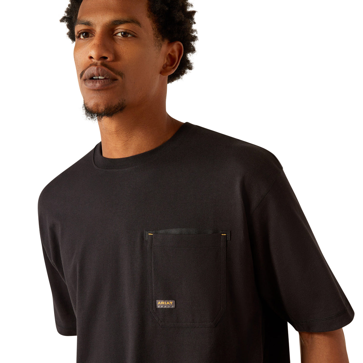 Person wearing a black t-shirt with 'Ariat Work' text on the back, standing against a white background