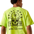 Person wearing a bright yellow t-shirt with a skull and hard hat graphic on the back.