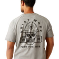 Man wearing a gray t-shirt with a skull and hard hat graphic on the back, on a white background