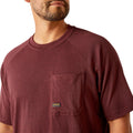 Man wearing a maroon t-shirt with a skull and hard hat graphic on the back, on a white background.