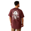 Man wearing a maroon t-shirt with a skull and hard hat graphic on the back, on a white background.