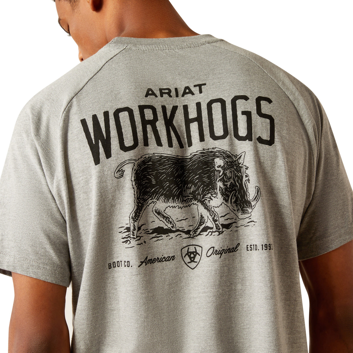 Person wearing a gray t-shirt with 'Ariat Workhogs' logo on the back