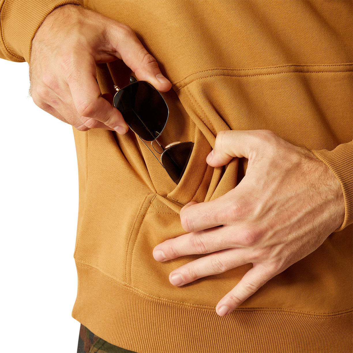Man wearing a brown hoodie with Ariat Work branding and cap on a white background