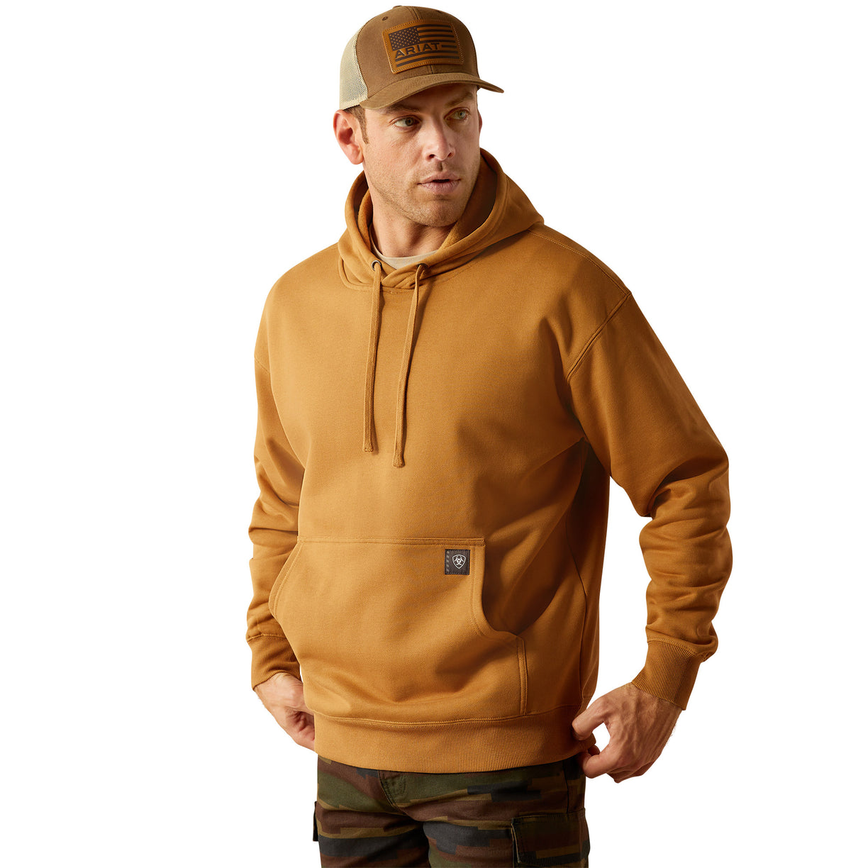 Man wearing a brown hoodie with Ariat Work branding and cap on a white background