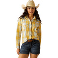Woman wearing a yellow plaid shirt, denim shorts, and a cowboy hat on a white background