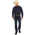 Man wearing a navy patterned shirt, jeans, and a straw cowboy hat on a white background