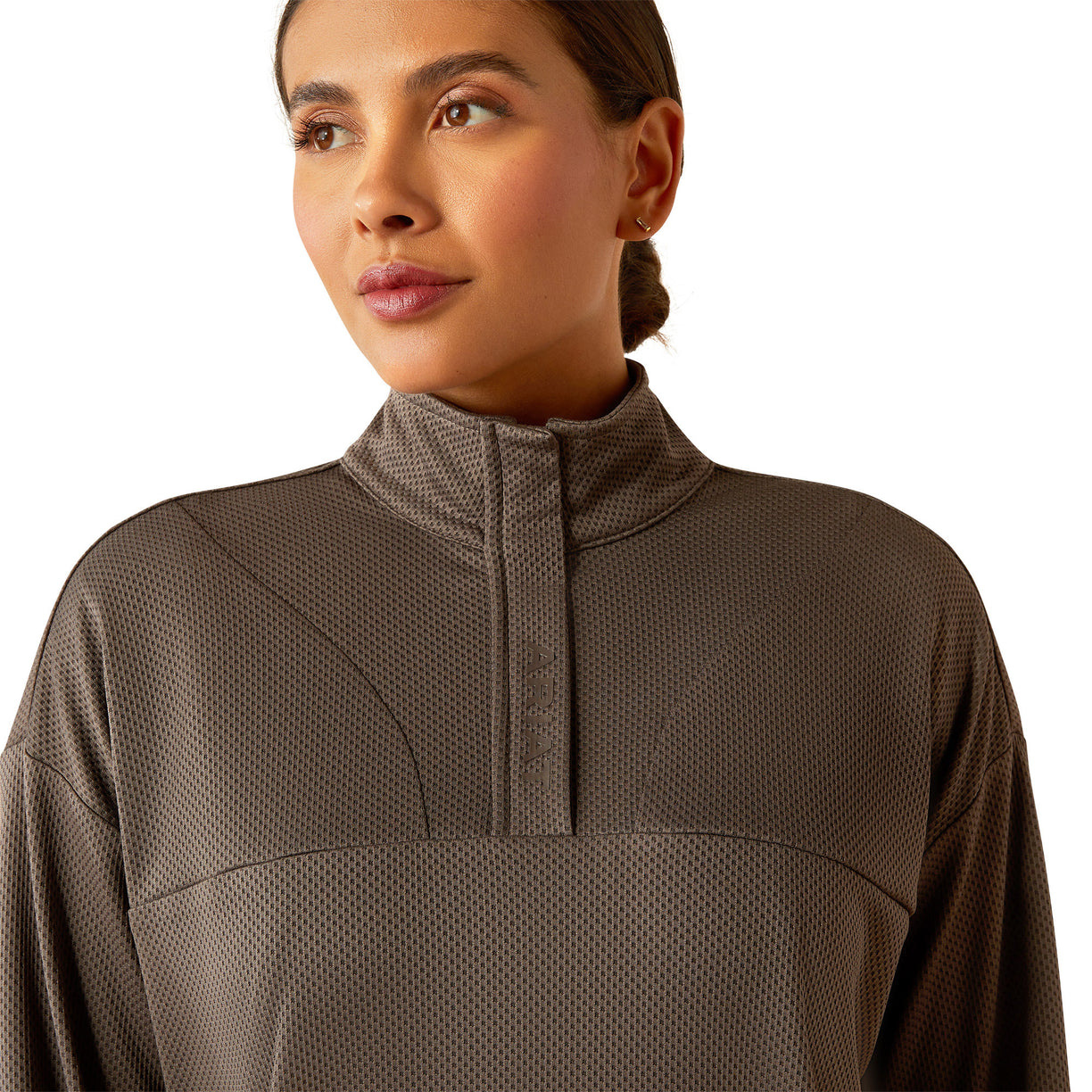 Woman wearing a brown long-sleeve athletic top and leggings on a white background