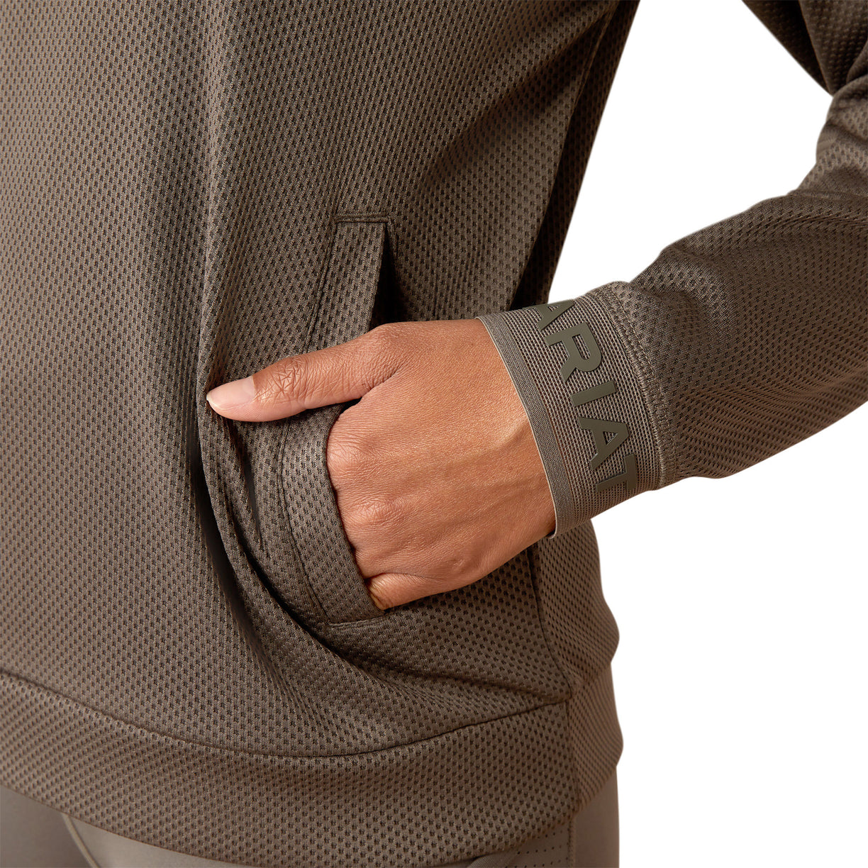Woman wearing a brown long-sleeve athletic top and leggings on a white background