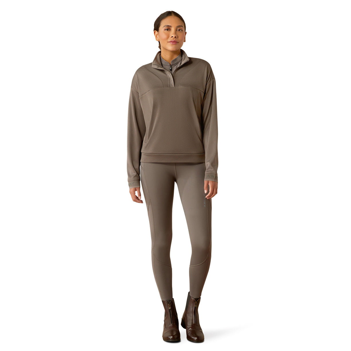 Woman wearing a brown long-sleeve athletic top and leggings on a white background