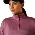 Woman wearing a pink pullover and cap on a white background