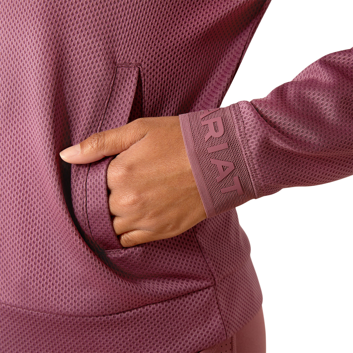 Woman wearing a pink pullover and cap on a white background