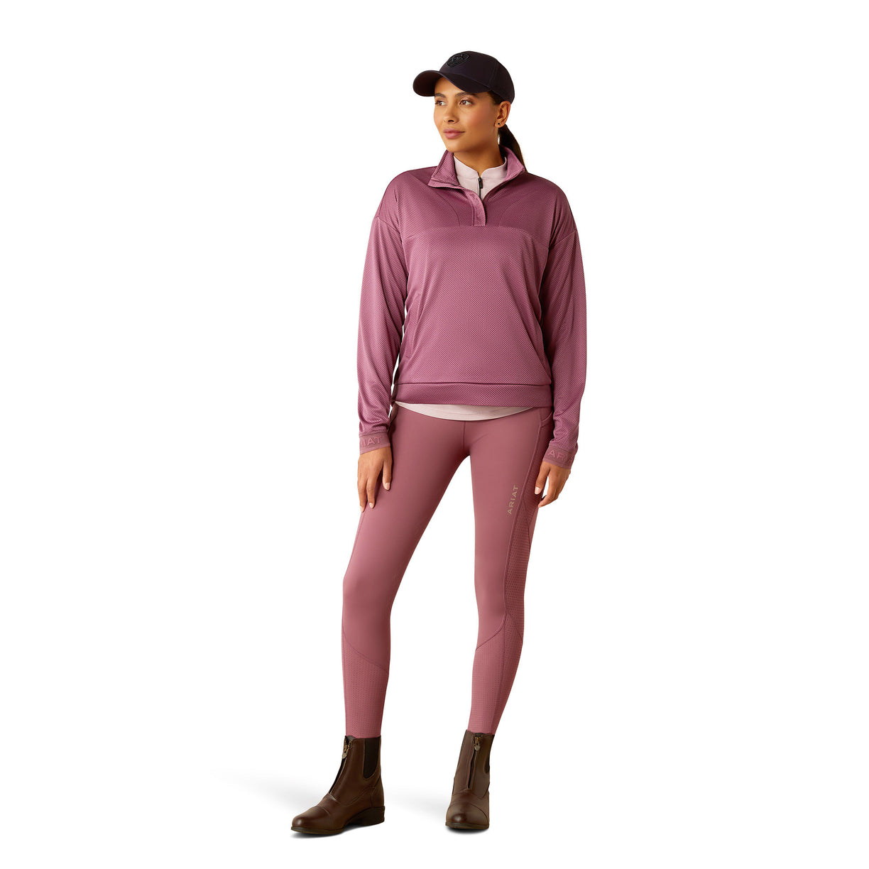 Woman wearing a pink pullover and cap on a white background