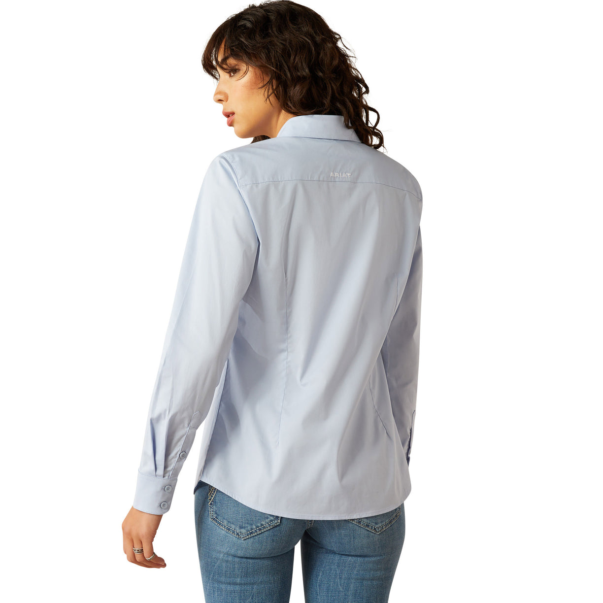 Woman wearing a light blue shirt and jeans on a white background
