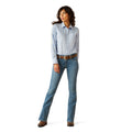 Woman wearing a light blue shirt and jeans on a white background
