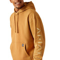 Man wearing a mustard yellow hoodie with Ariat branding on a white background