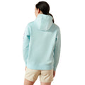Person wearing a light blue hoodie with 'Ariat' branding on a white background