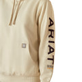 Woman wearing a beige hoodie with Ariat brand logo on a white background