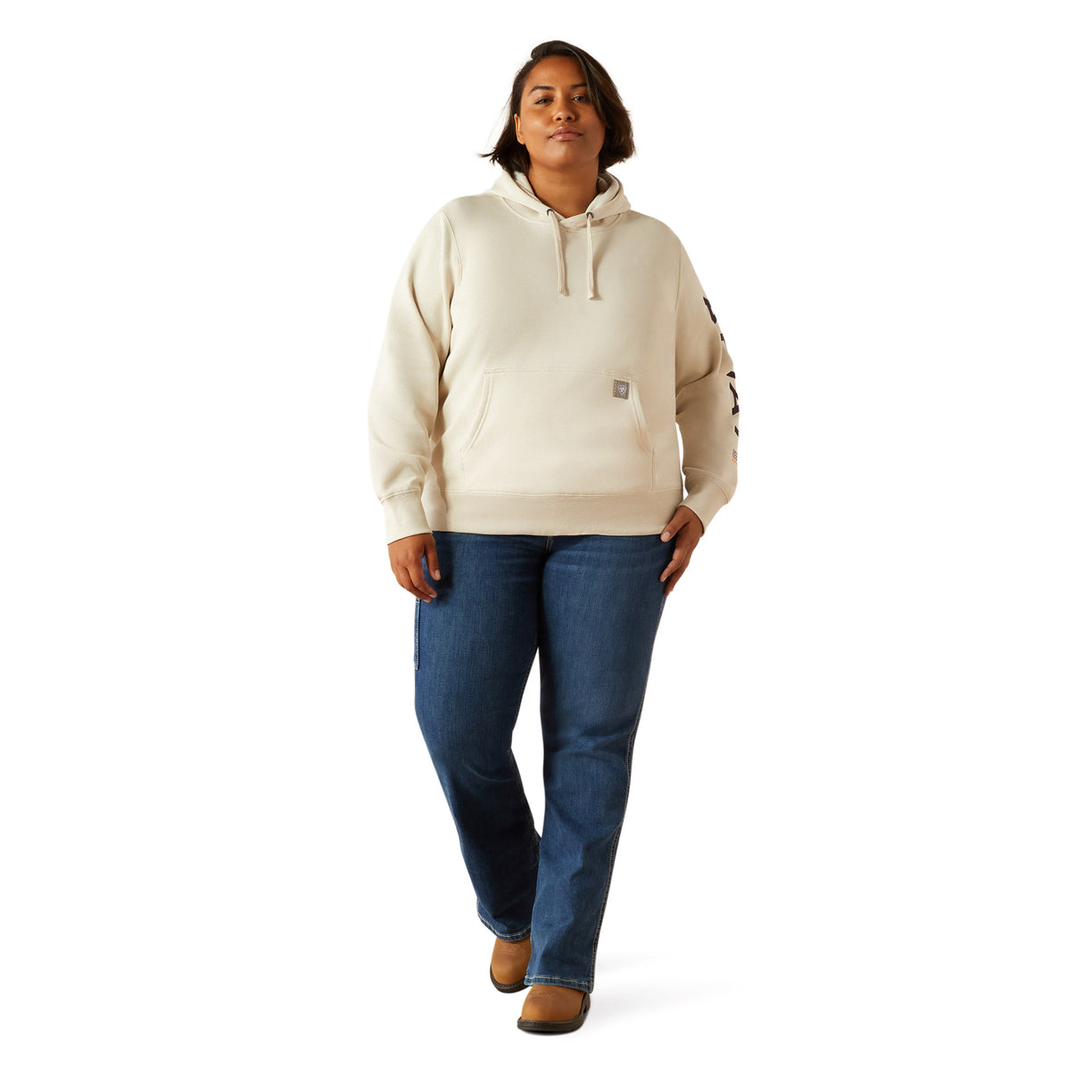 Woman wearing a beige hoodie with Ariat brand logo on a white background