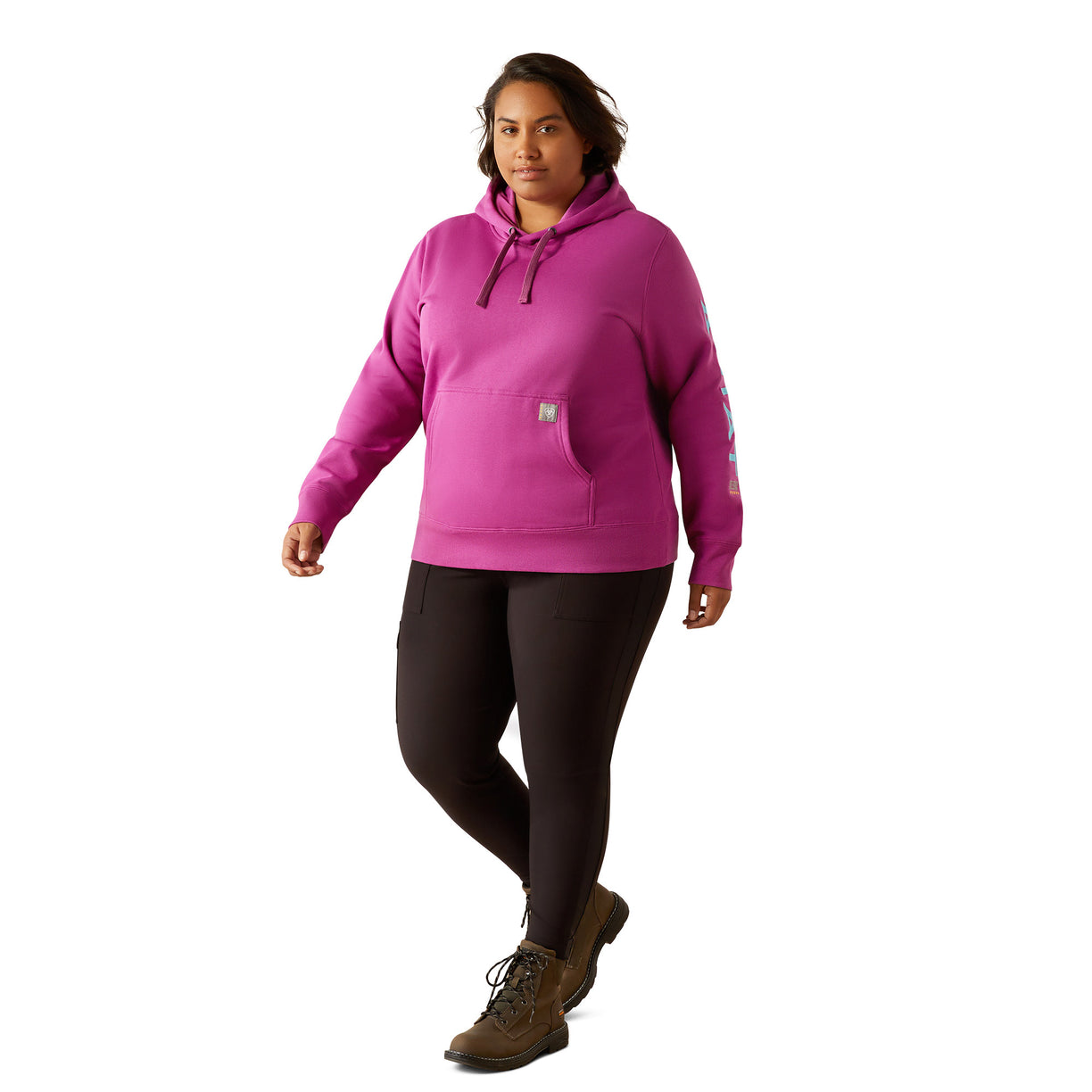 Person wearing a pink hoodie with Ariat brand logo on a white background