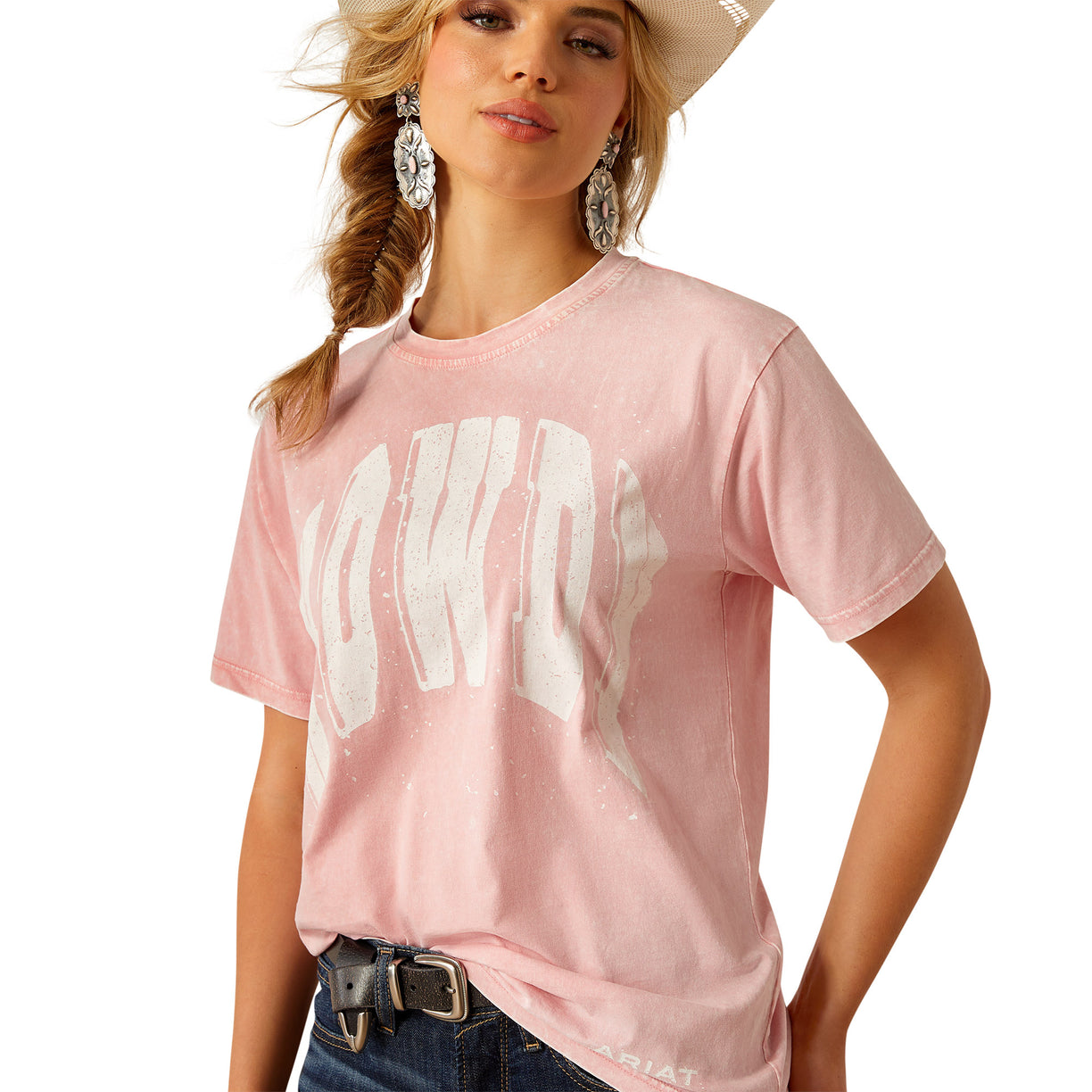 Woman wearing a pink t-shirt with white text, denim shorts, and a cowboy hat on a white background
