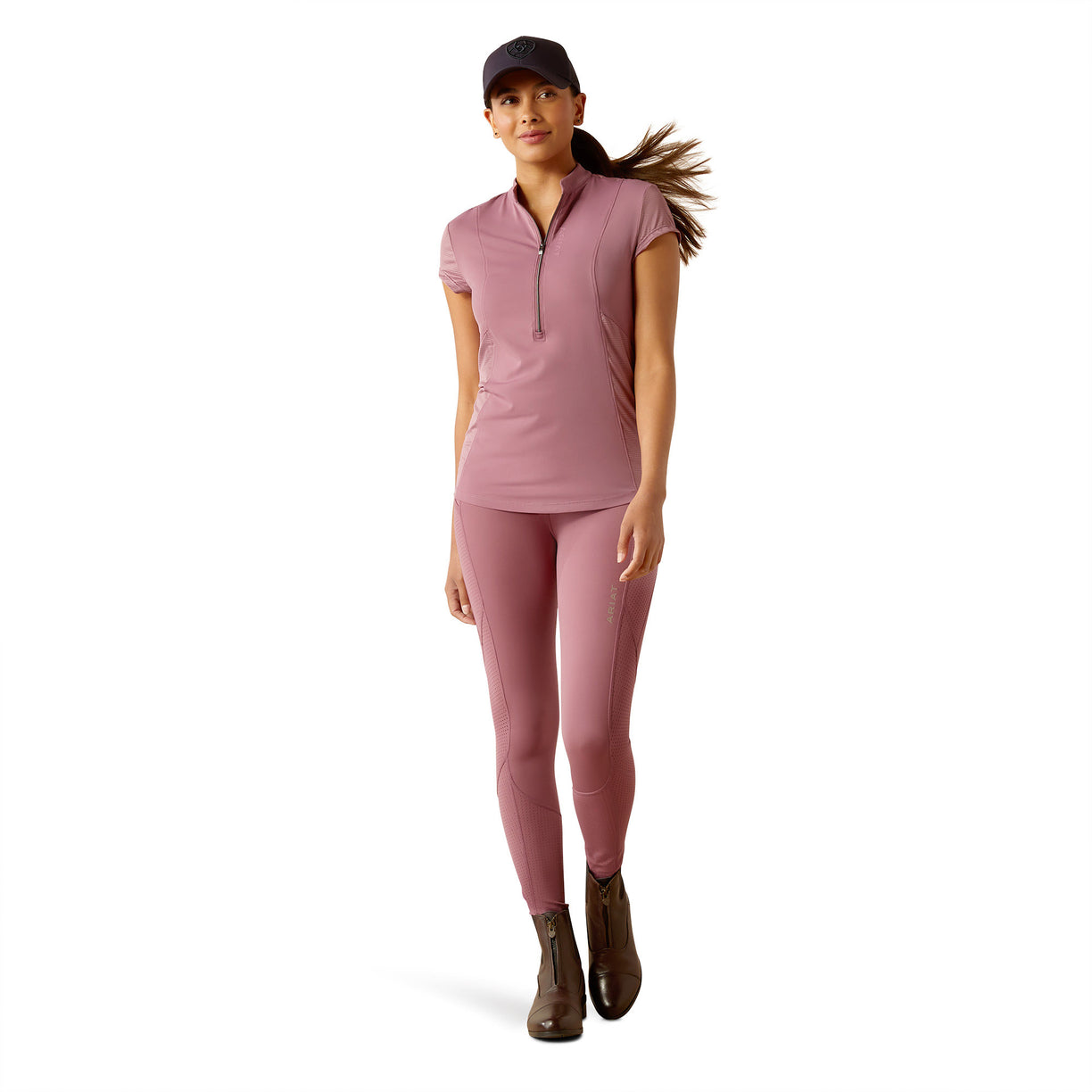 Woman wearing a pink outfit with a cap on a white background