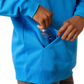 Man wearing a blue hoodie with Ariat brand logo on a white background