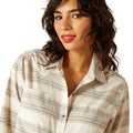 Woman wearing a striped shirt with a plain background