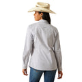 Woman wearing a patterned shirt, jeans, and a cowboy hat on a white background