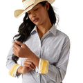 Woman wearing a patterned shirt, jeans, and a cowboy hat on a white background