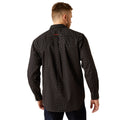 Man wearing a black patterned shirt on a white background