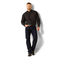Man wearing a black patterned shirt and dark jeans on a white background