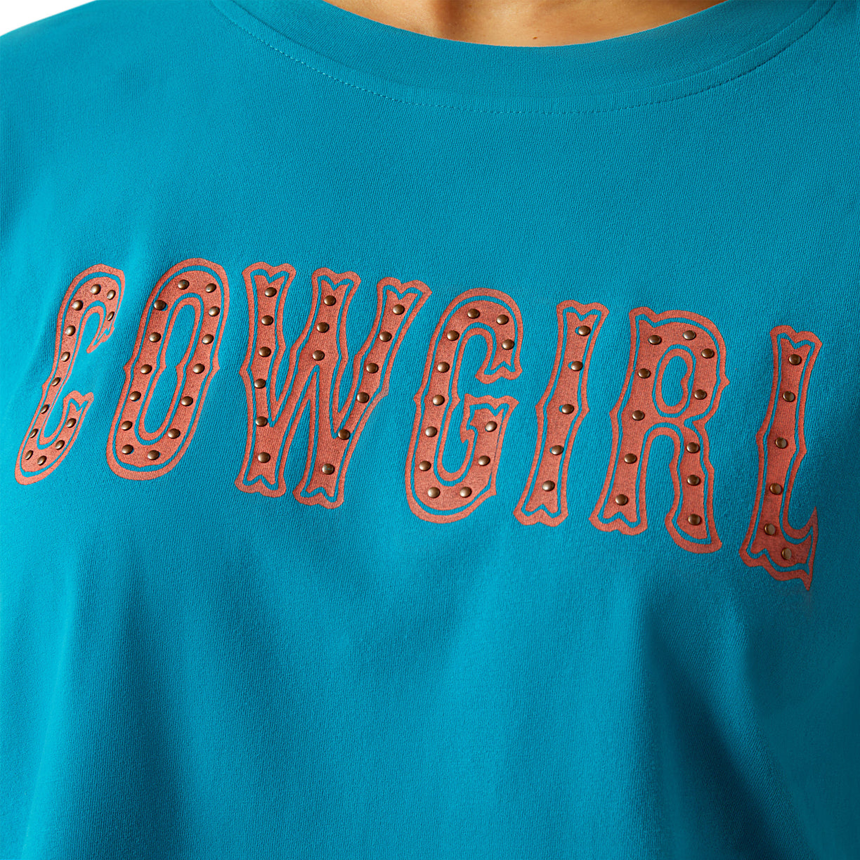Woman wearing a blue t-shirt with 'COWGIRL' text on a white background