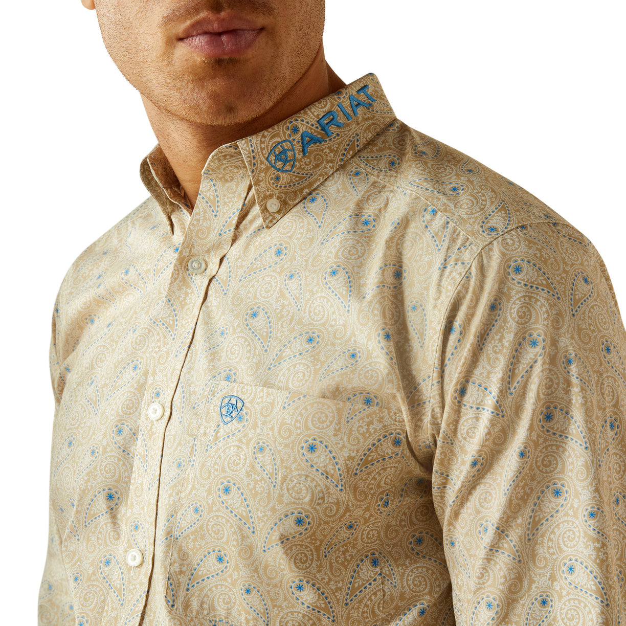 Man wearing a beige patterned shirt with 'Ariat' branding on the collar.
