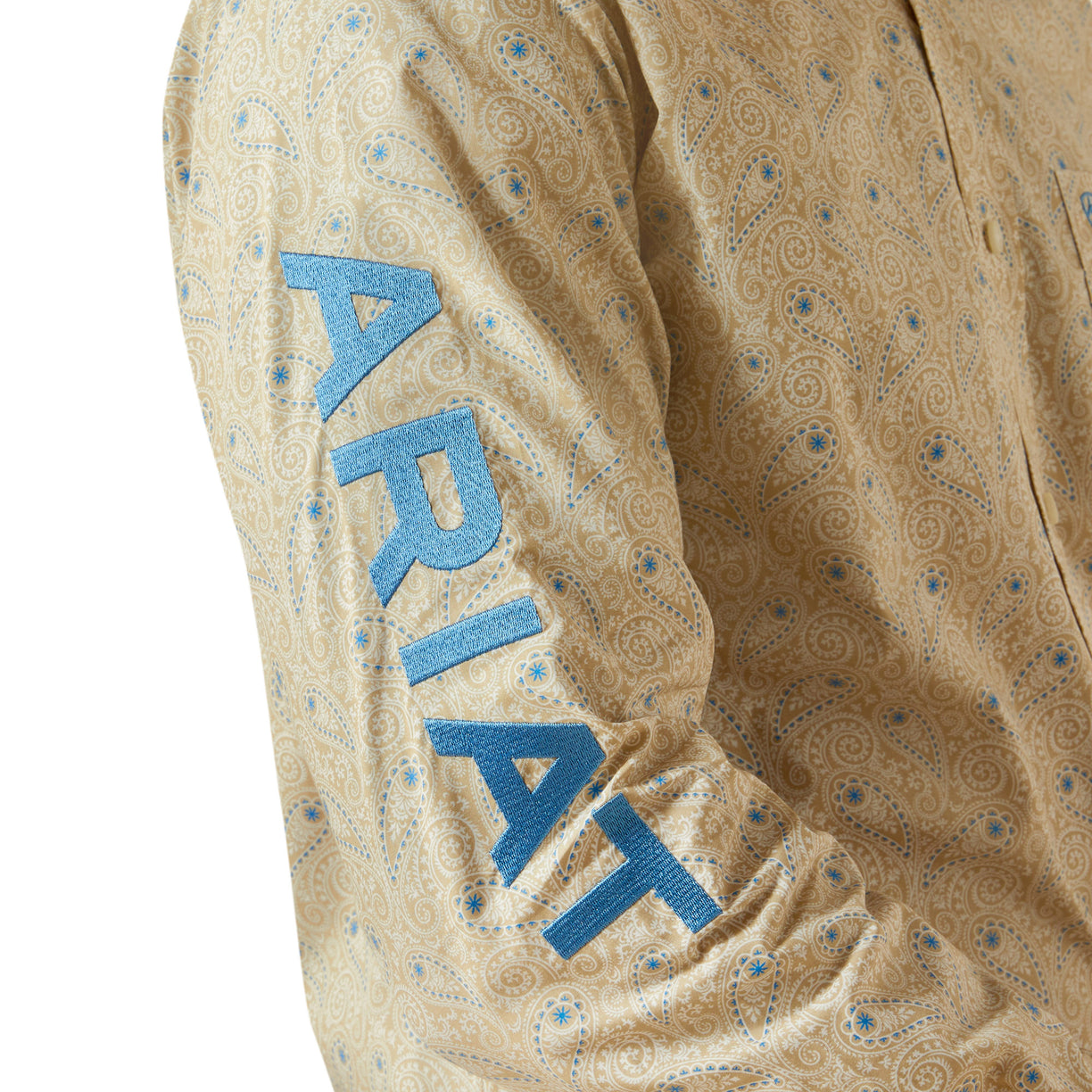 Close-up of a patterned shirt with 'Ariat' branding on a beige background