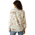 Woman wearing a cream-colored shirt with brown patterns on a white background