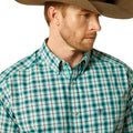 Man wearing a green plaid shirt and brown cowboy hat on a white background