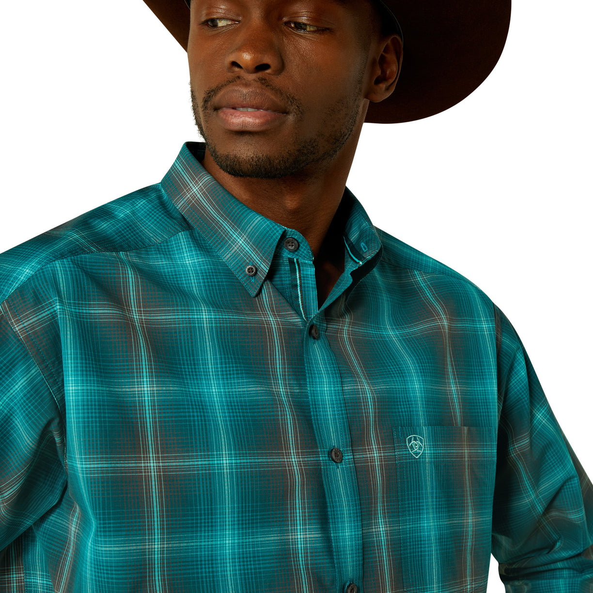 Man wearing a teal plaid shirt with a brand logo on a white background