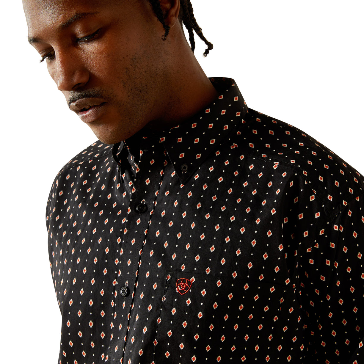 Man wearing a black patterned shirt with a close-up view.