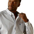 Man wearing a patterned shirt with a visible brand logo on a white background