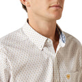 Close-up of a man wearing a patterned shirt with a visible brand logo.