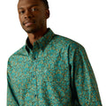 Man wearing a teal patterned shirt on a white background