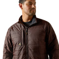 Man wearing a brown quilted jacket on a white background