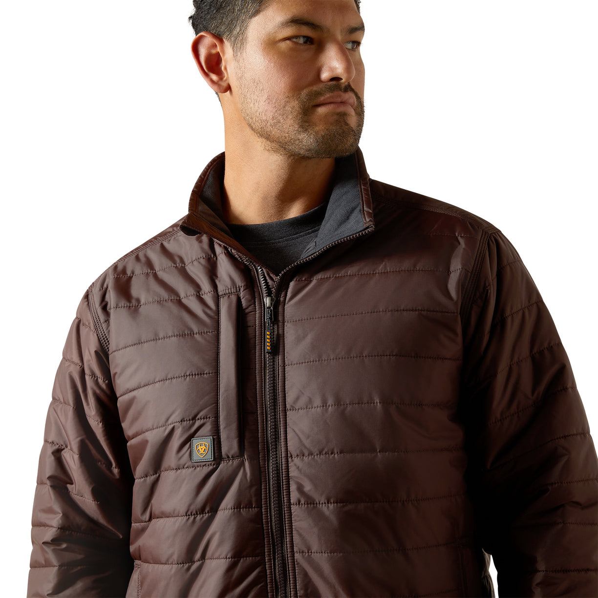 Man wearing a brown quilted jacket on a white background