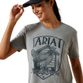 Woman wearing a gray t-shirt with 'Ariat Family Farm' graphic design.