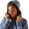 Woman wearing a blue hoodie with the hood up on a white background