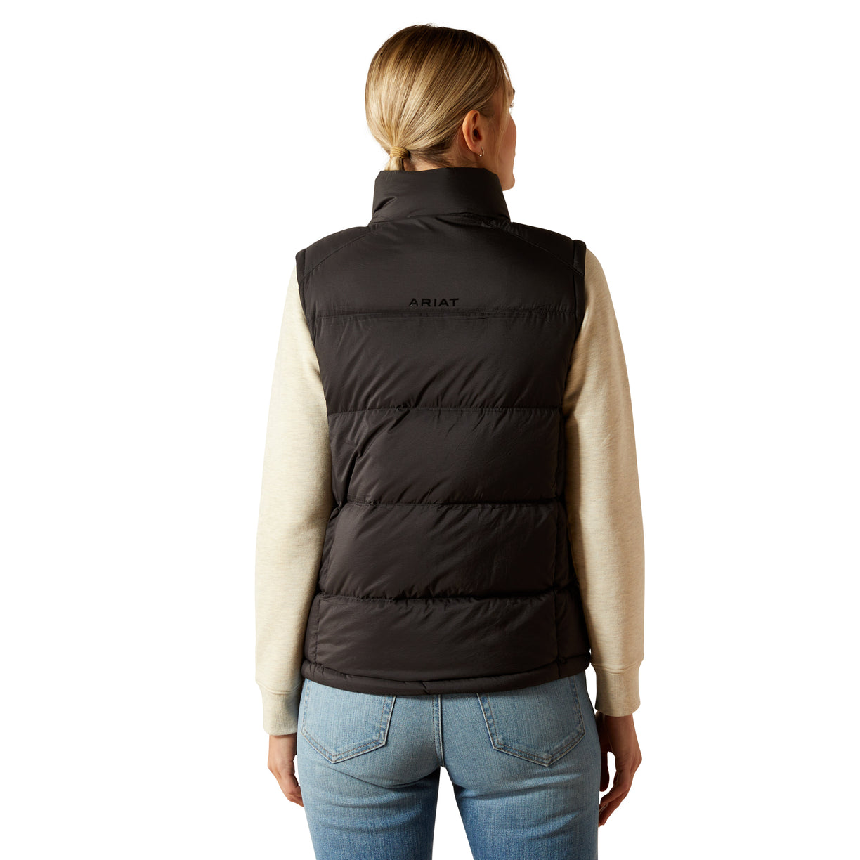 Person wearing a black puffer vest with 'Ariat' branding on a white background